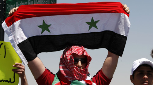 A Syrian protester holds up a Syrian national flag during a demonstration attended by Syrians living in Jordan against Bashar's government and the ruling Baath Party in front of Syrian embassy in Amman, capital of Jordan, on April 24, 2011. (Xinhua-Yonhap News)