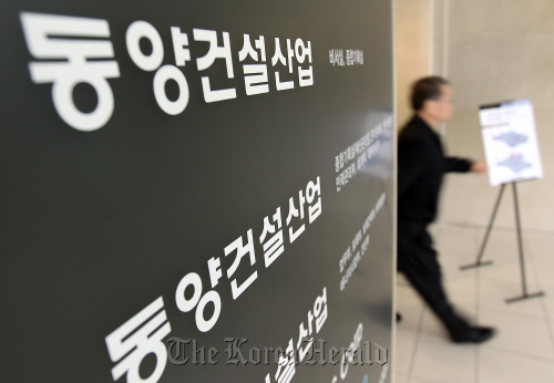 A man walks by a sign at Dongyang Engineering and Construction Corp.’s office in Seoul on Monday, as concerns rise over the possibility that numerous construction firms may follow Dongyang into insolvency. (Yonhap News)