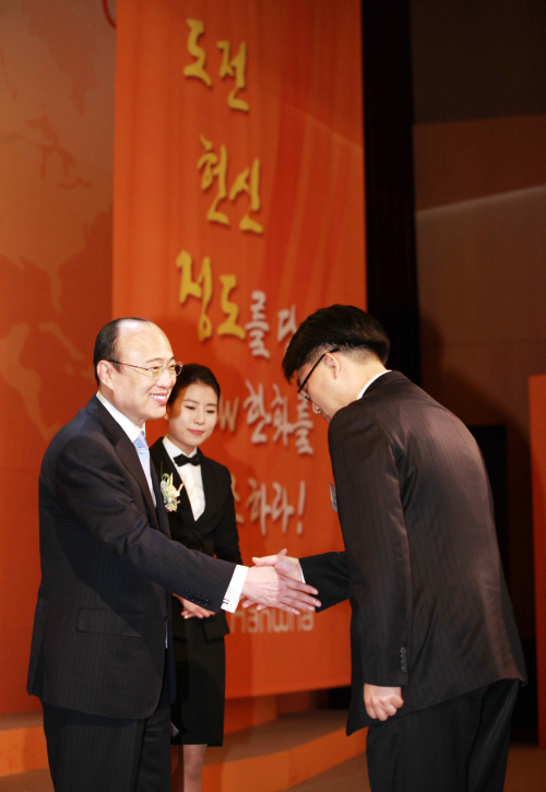 Hanwha Group chairman Kim Seung-youn (left) shakes hands with a representative of Hanwha employees at the ceremony declaring the group’s new core values at the Hanwha HRD Center in Gyeonggi Province on Monday. (Yonhap News)