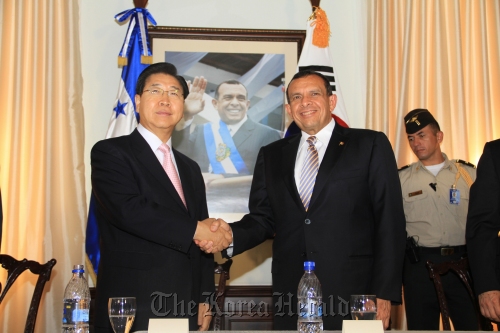 POSCO chief executive Chung Joon-yang (left) and Honduras President Porfirio Lobo Sosa shake hands after signing an MOU on the country’s infrastructure in Honduras on Wednesday. (POSCO)