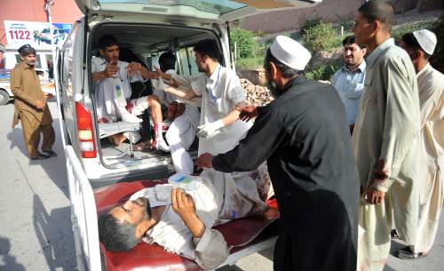 Pakistani paramedics help injured blast victims as they arrive at a hospital in Peshawar on Friday following a suicide and bomb attack on the paramilitary police in the northwestern Charsadda district. (AFP)