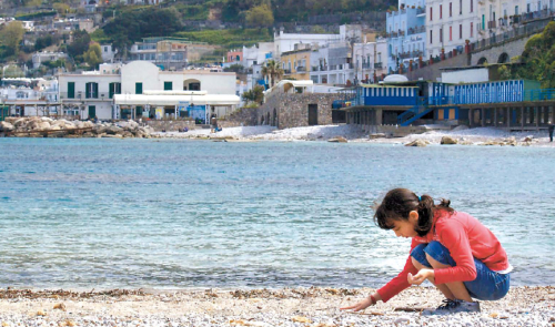 Joie, 10, looks for sea glass on a rocky beach near Marina Grande on the island of Capri, Italy. (Charlotte Observer/MCT)