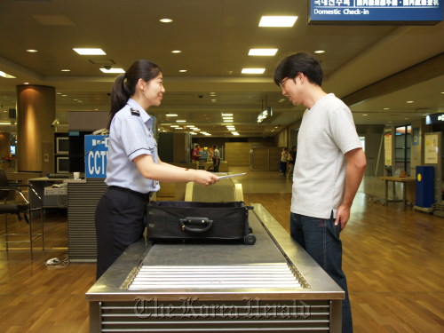 A Korea Customs Service worker inspects a traveller’s bag at Incheon International Airport. (KCS)