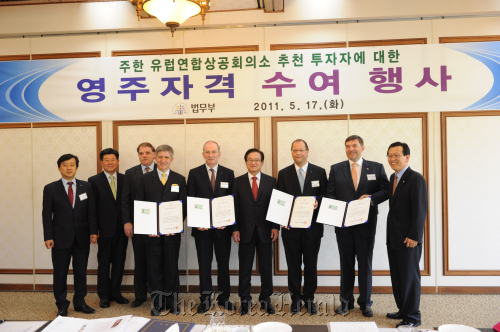 European investors pose with officials at the Ministry of Justice and the European Union Chamber of Commerce in Korea after receiving Korean permanent residency Tuesday at the ministry in Seoul. From left: Jee Dong-hoon, the EUCCK deputy secretary general; Han Myung-kwan, deputy justice minister; Jean-Jacques Grauhar, the EUCCK secretary general; Wolfgang Slawinski, chief executive of Frequent-ATM Communication; Friedrich Stockinger, president of Trumpf Korea; Lee Kwi-nam, justice minister; Patrick Mange, deputy chief executive of BNP Paribas; Holger Doerre, managing director of Harting Korea Ltd.; Seok, Dong-hyeon, commissioner of immigration service at the ministry. (EUCCK)