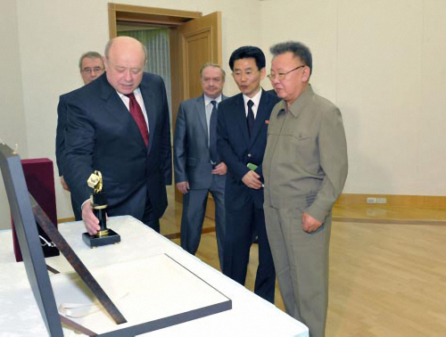 Mikhail Fradkov (left), head of the foreign intelligence service of the Russian Federation, shows a gift presented to North Korean leader Kim Jong-il in Pyongyang on May 17. (Yonhap News)