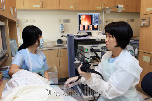 Jung Hye-kyung, gastroenterology professor, conducts a colonoscopy on a patient. (Ewha Womans University Medical Center.)
