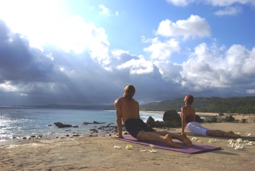 A couple practices yoga on a stretch of Nihiwatu’s two and a half kilometer beach. (Nihiwatu)