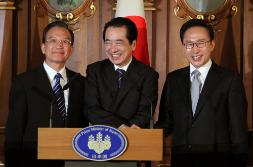 Korean President Lee Myung-bak (right), Chinese Prime Minister Wen Jiabao (left) and Japanese Prime Minister Naoto Kan shake hands after their joint news conference in Tokyo after the annual tripartite summit Sunday. (Yonhap News)