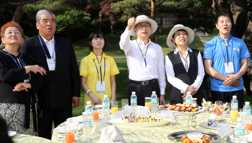 President Lee Myung-bak (third from right) and First Lady Kim Yoon-ok (second from right) meet volunteers and officials of World Friends Korea programs at Cheong Wa Dae on Monday. (Yonhap News)