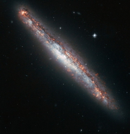 This NASA/ESA Hubble Space Telescope image shows the edge-on profile of the slender spiral galaxy NGC 5775, which is surrounded by a halo of gas that astronomers suspect is kicked up by star explosions like a galaxy-size fountain. (NASA)