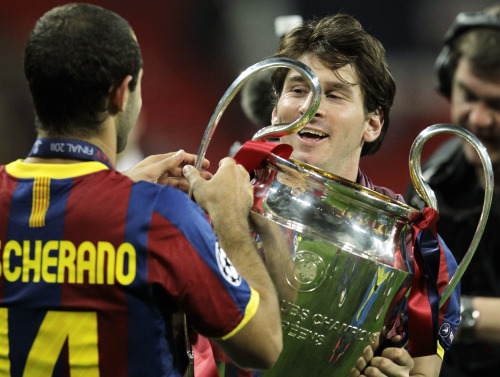 Barcelona's Lionel Messi, right, and Javier Mascherano celebrate with the trophy after winning the Champions League final soccer match against Manchester United at Wembley Stadium, London, Saturday, May 28, 2011. (AP-Yonhap News)