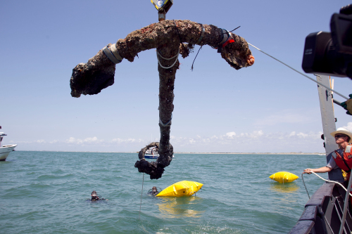A 3,000 pound anchor from what is believed to be the wreck of the pirate Blackbeard's flagship, the Queen Anne's Revenge, is recovered from the ocean where it has been since 1718, on Friday, May 27, 2011 in Beaufort Inlet, in Carteret County N.C. Crew member Mitchel Gilliland, right, helps guide the anchor aboard the Dan K. Moore. (AP-Yonhap News)