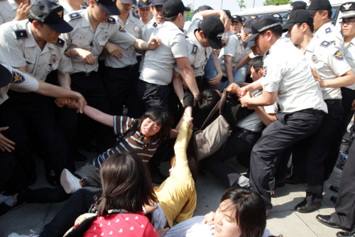 Police restrain students who attempted a surprise march to Cheong Wa Dae during their demonstration in Gwanghwamun Square on Sunday, demanding a tuition cut and measures against unemployment. (Yonhap News)
