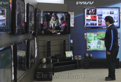 A sales clerk inspects liquid-crystal display televisions at Samsung Electronics Co.’s store in Seoul. (Bloomberg)