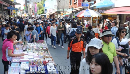 The main street of Insa-dong bustles with street vendors, shoppers and tourists Sunday. (Lee Sang-sub/The Korea Herald)