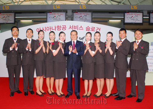 Asiana Airlines chief executive Yoon Young-doo (center) and staff members clap during a ceremony at Incheon International Airport on Thursday to introduce the carrier’s new service slogan and uniforms. (Asiana Airlines)