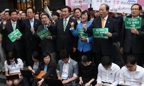 Democratic Party leader Sohn Hak-kyu (center in front row), flanked by other opposition leaders, joins a rally in Seoul calling for college tuition cuts last Friday. (Yonhap News)
