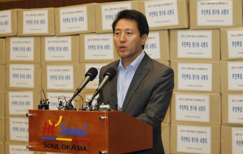 Seoul Mayor Oh Se-hoon addresses a news conference in front of boxes filled with signatures calling for a referendum on free school meals at City Hall earlier this month. (Yonhap News)