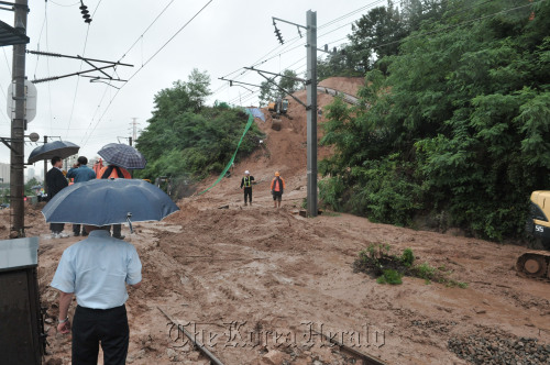 Mud blankets a subway rail in Seoul on Wednesday after a landslide caused by heavy rain. One person died and two others were injured in the accident. (Chung Hee-cho/The Korea Herald)