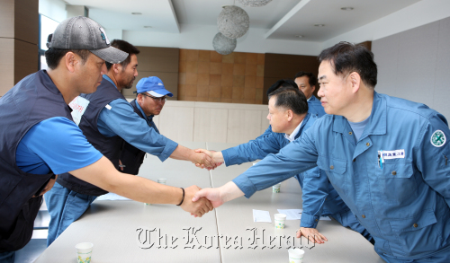 Hanjin Heavy Industries and Construction Co.’s management and union leaders including chief of the company’s shipbuilding business Lee Jae-yong (first from right) and the company’s union leader Chae Gil-yong (left) shake hands after signing a labor-management agreement at the company’s office in Busan on Wednesday. (Yonhap News)