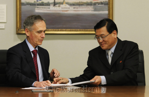 North Korea’s Kim Pyong-ho (right), president of Korean Central News Agency, exchanges an agreement during an official signing with Associated Press President and CEO Tom Curley in New York on Tuesday. (AP-Yonhap News)