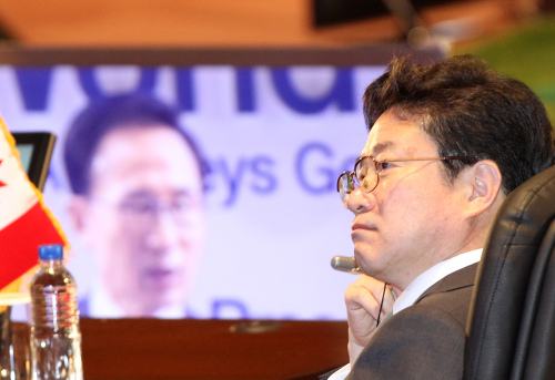 Prosecutor General Kim Joon-gyu listens as President Lee Myung-bak makes an opening speech at an international conference of chief prosecutors in Seoul on Thursday. (Yonhap News)