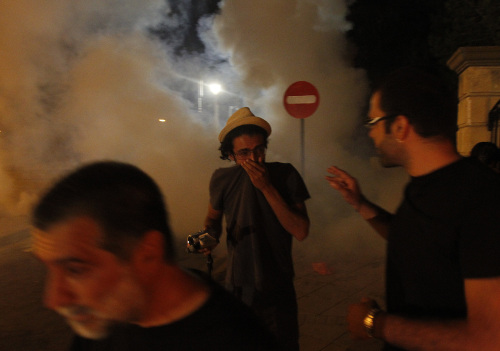 Cypriot protesters run outside of the presidential palace in Nicosia on Tuesday. (AP-Yonhap News)