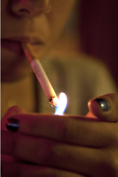 A woman lights a cigarette for a photograph in New York, U.S. (Bloomberg)