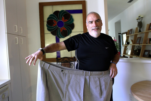 A man had bariatric surgery and then transferred his addiction to food to an alcohol. He checked himself into rehab, and has been sober ever since. Here he is poses with his size 64 pants. (MCT)