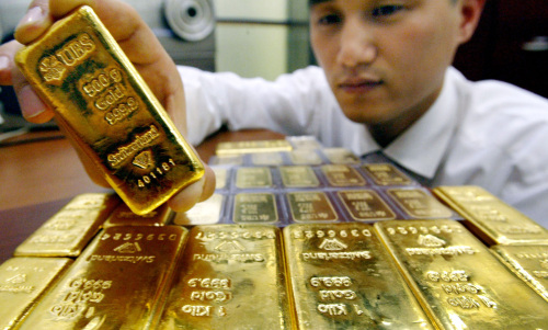 An employee at Shinhan Bank shows gold bullion bars. (Ahn Hoon/The Korea Herald)