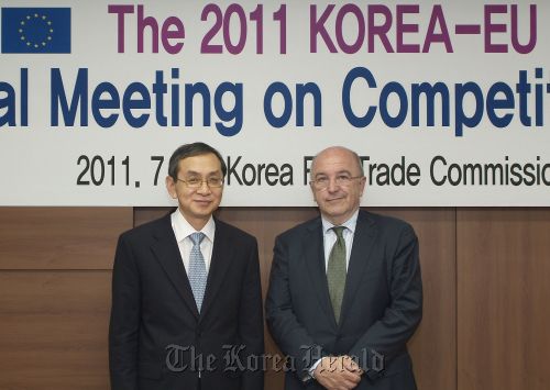 Fair Trade Commission chief Kim Dong-soo (left) poses with Joaquin Almunia, vice president of the European Commission, after holding a policy meeting in Seoul on Friday. (Yonhap News)