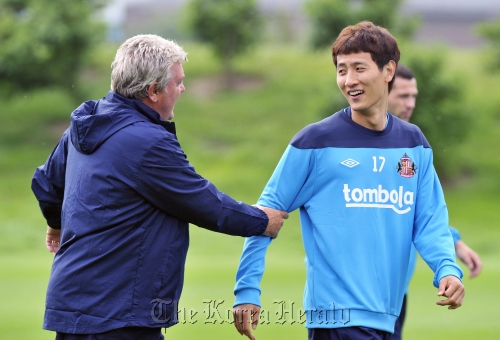Sunderland’s new striker Ji Dong-won (right) of Korea speaks with manager Steve Bruce on Friday. (Sunderland)