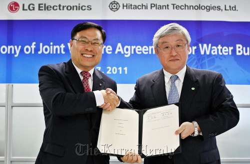 LG Electronics’ home appliance president Lee Young-ha (left) shakes hands with Hitachi Plant Technologies president Toshiaki Higashihara after signing an agreement to establish a new joint venture named LG-Hitachi Water Solutions Co. at LG Twin Towers in Yeouido, Seoul, early this month. (LGE)