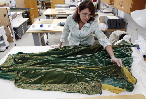 Cara Varnell, an independent art conservator who specializes in Hollywood film costumes, works with the green velvet gown from the film “Gone With the Wind,” on Tuesday in Austin, Texas. (AP-Yonhap News)