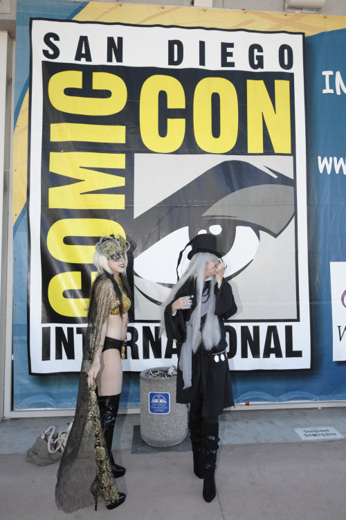 Two costumed characters wait in front of a Comic Con logo before Preview Night at the Comic-Con 2011 convention Wednesday in San Diego. (AP-Yonhap News)