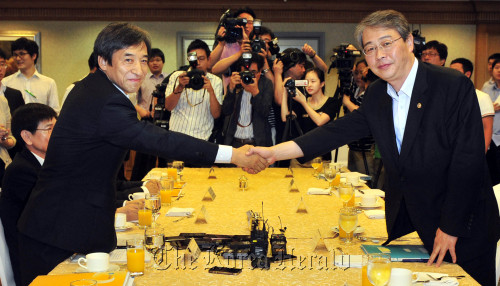 Lee Ju-yeol (left), senior deputy governor at the Bank of Korea, shakes hands with Lim Jong-yong, vice finance minister, at the first policy coordination meeting held at the Korea Federation of Banks in Seoul on Monday. (Kim Myung-sub/The Korea Herald)