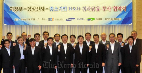 Minister of Knowledge Economy Choi Joong-kyung (fifth from right, front row) and Samsung Electronics vice chairman Choi Gee-sung (fourth from right, front row) pose with representatives of SMEs after signing the R&D support agreement in Seoul on Monday. (Kim Myung-sub/The Korea Herald)