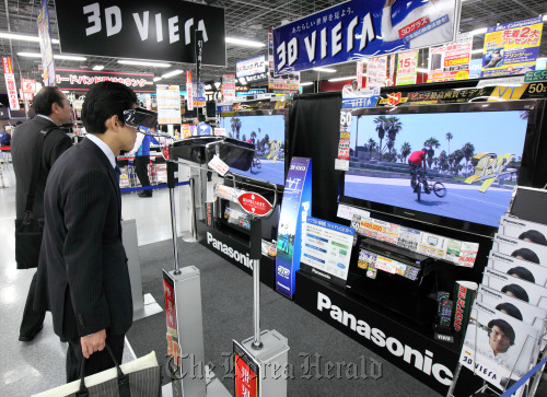 Customers look at Panasonic Corp.’s 3-D televisions at an electronics store in Tokyo. (Bloomberg)