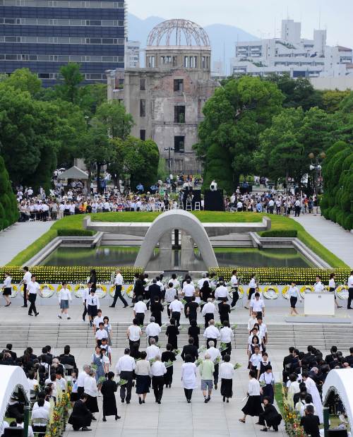 People carry flowers to the alter at the Peace Memorial Park to commemorate the 1945 atomic bombing of Hiroshima at Hiroshima on Saturday. (AFP-Yonhap News)