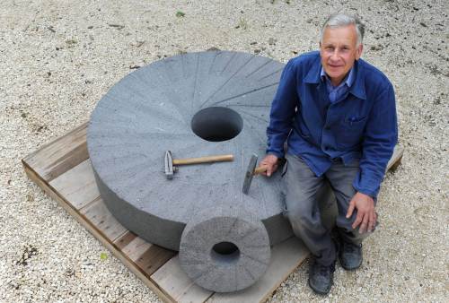 Wolfgang Starkosch sits on a new millstone he made in the village of Zusamaltheim. (AFP-Yonhap News)