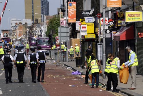 Volunteers (right) clean up in Croydon, south of London, on Wednesday, following riots in the area. (AFP-Yonhap News)