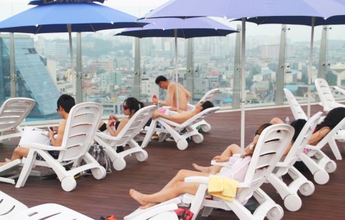 People sunbathe on a rooftop. Health experts claim it is extremely important to restore your biorhythm after the holidays. (Yonhap News)