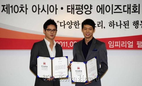 Kim Jun-su (left) and Park Yu-chun of the K-pop idol group JYJ pose for a photo at a hotel in Seoul, after being appointed PR ambassadors of the 10th International Congress on AIDS in Asia and the Pacific, which will kick off on Aug. 26 in Busan. (Park Hae-mook/The Korea Herald)