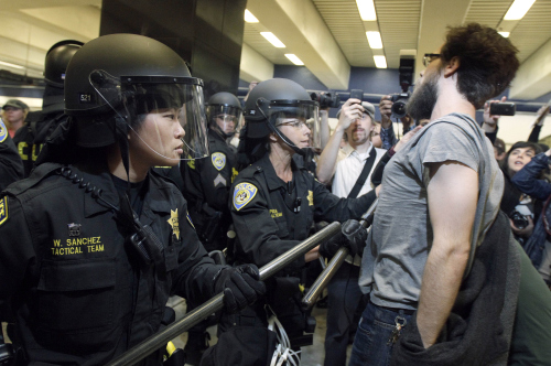 BART police officers push back a protester at the Civic Center station in San Francisco, Monday. (AP-Yonhap News)