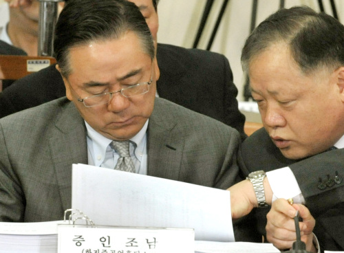 Cho Nam-ho (left), chairman of Hanjin Heavy Industries & Construction Co., reads prepared documents ahead of a parliamentary hearing on the company’s recent labor dispute at the National Assembly in Seoul on Thursday. (Yang Dong-chul/The Korea Herald)