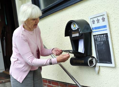 Heidemarie Schwermer empties the letter box of a house she is homesitting in Wilhelmshaven, northern Germany, in July 2011. (AFP-Yonhap News)