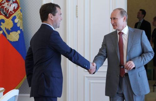 Vladimir Putin (right) shakes hands with Dmitry Medvedev during their meeting in presidential residence Bocharov Ruchei outside Sochi on Aug. 5. (AFP-Yonhap News)