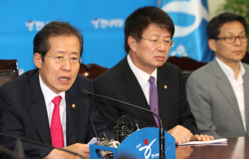 Hong Joon-pyo (left), chairman of the ruling Grand National Party, holds a press conference at the party’s headquarters in Seoul on Wednesday, after the referendum was declared invalid due to low voter turnout. (Yonhap News)
