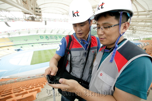 Two KT officials check wireless Internet services at the main stadium for the Daegu World Championships in Athletics in Daegu, northern Gyeongsang Province, earlier this week.