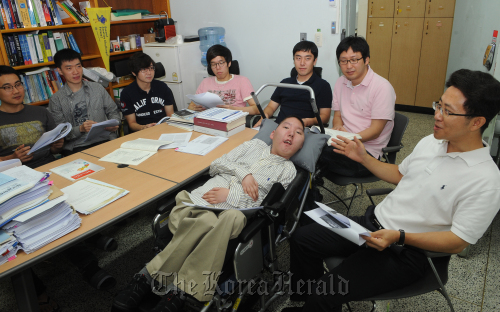 Shin Hyung-jin, a researcher at the Research Center for Software Application at Yonsei University, listens to his professor with his colleagues at a seminar. (Lee Sang-sub/The Korea Herald)